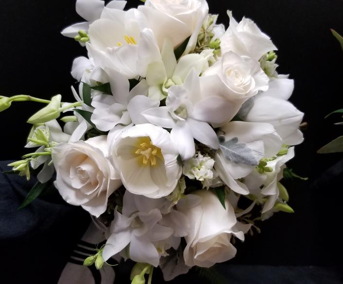 White Dendrobium Orchids, Tulips, Roses and larkspur create this beautiful Bouquet