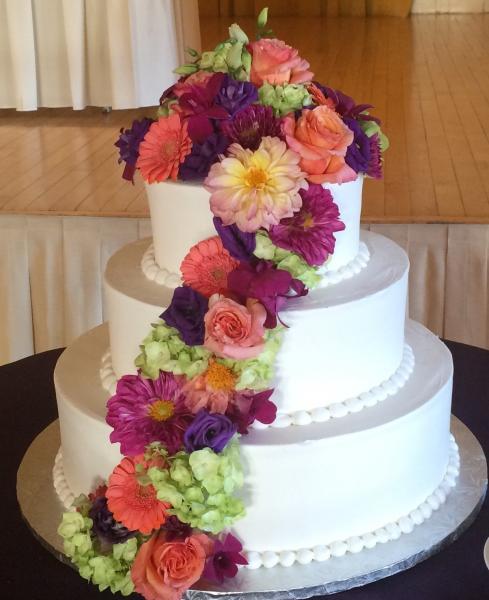 Gorgeously lit and cascading with beautiful roses and hydrangeas in shades of pink and whites, accented with jewels; this cake display steals the spotlight.